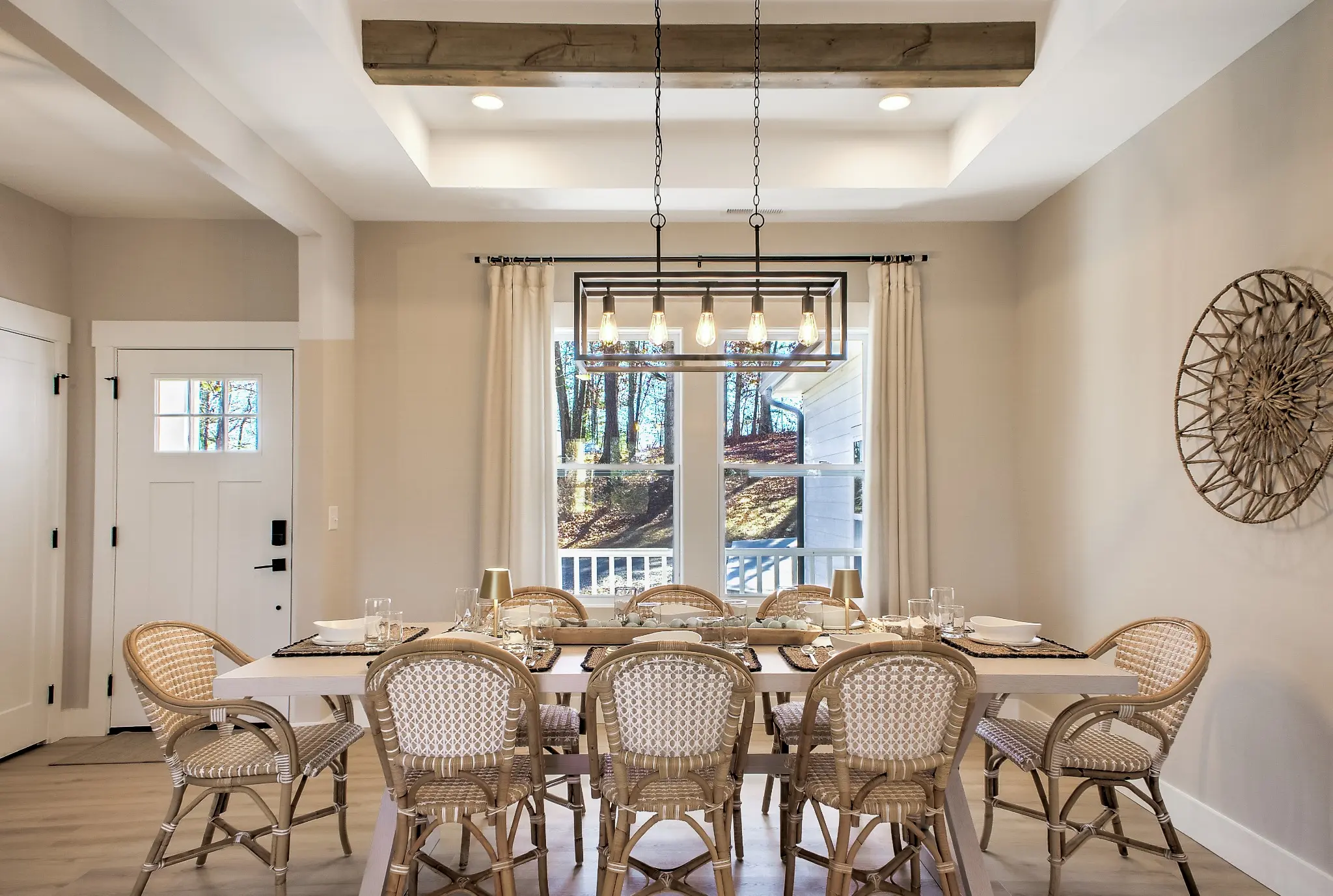 Dining room with a round table, woven chairs, and modern light fixture
