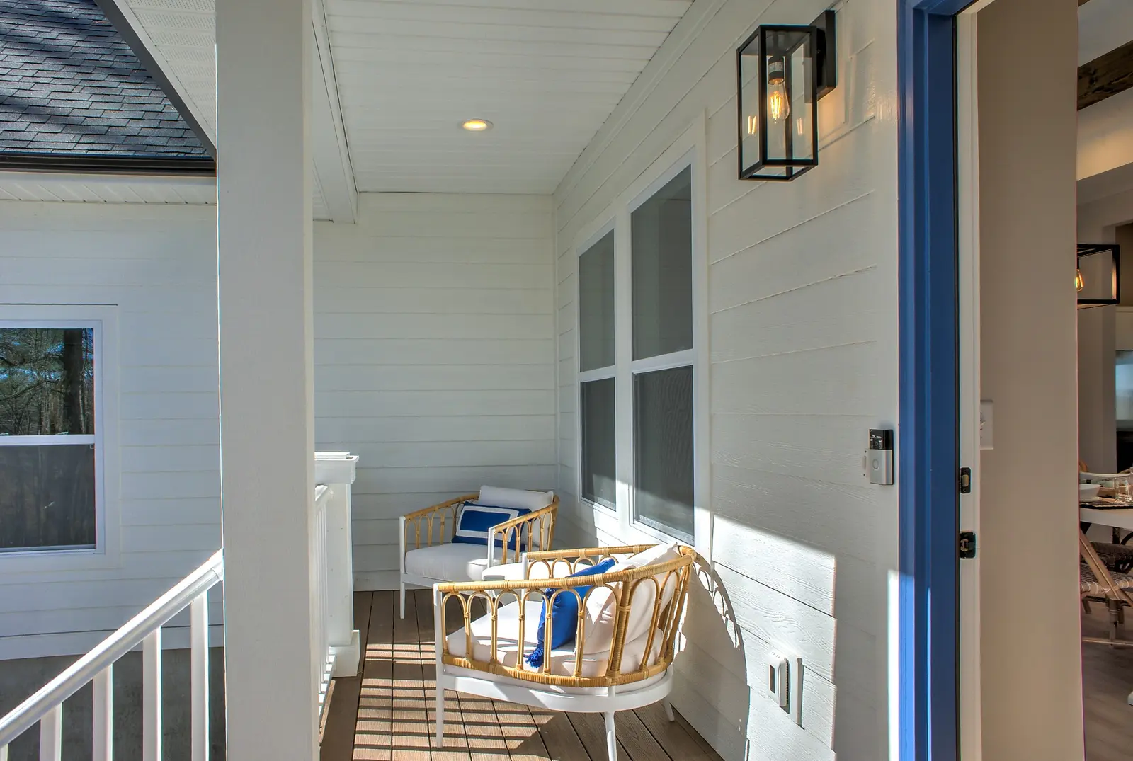 Covered front porch seating outside the blue front door