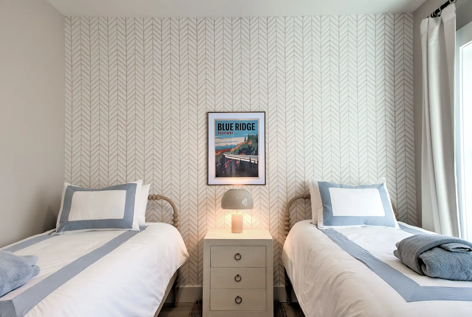 Twin bedroom with light blue bedding and Blue Ridge artwork