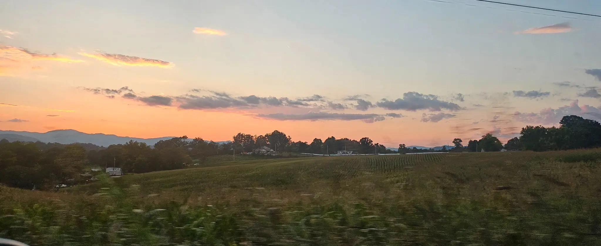 Warm sunset over fields and distant mountains in Western North Carolina